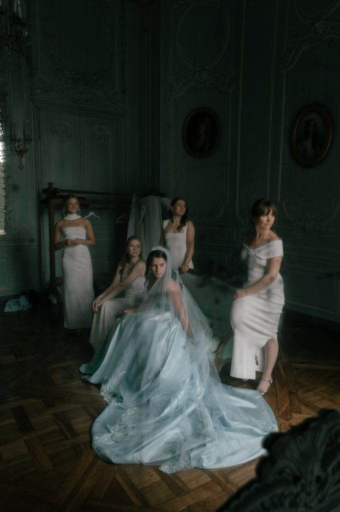 Four bridesmaids all look together in the same direction surrounding a bride wearing blue, taken by London Wedding Photographer Philip White.