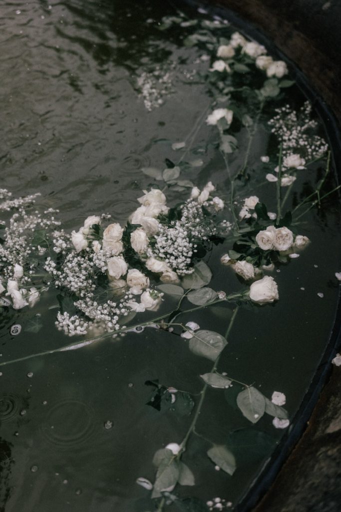 A bridal bouquet lies in a fountain at the end of the wedding day, taken by London Wedding Photographer Philip White.